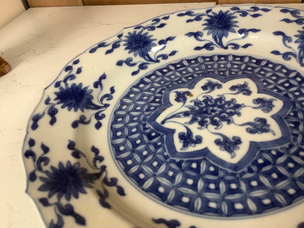 A pair of Chinese blue and white porcelain plates, Kangxi mark and period, with shaped borders and floral motifs, diameter 20cm